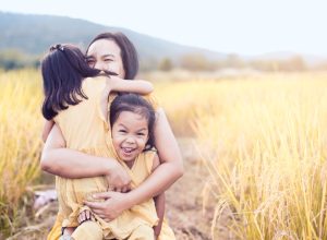 woman sitting outside with daughters, parenting tips