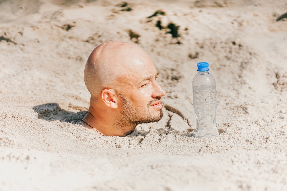 Man Buried in the Sand Funny Stock Photos