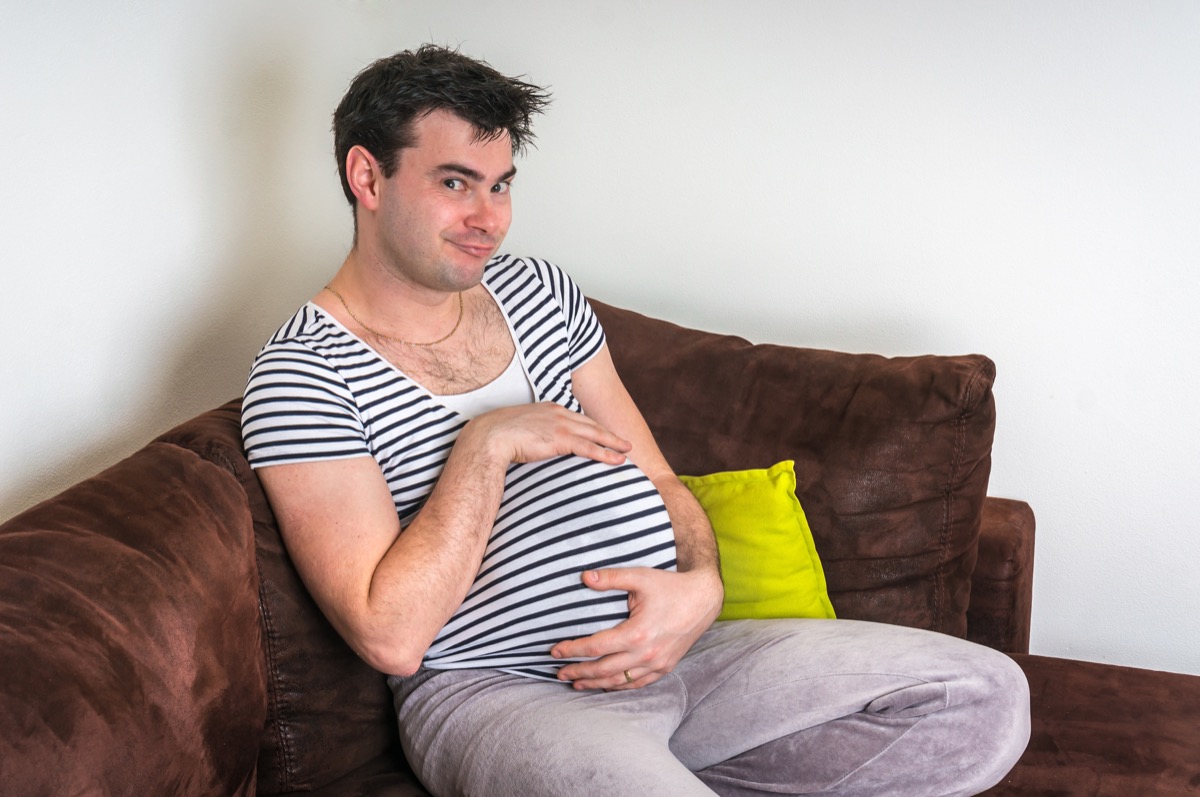 Pregnant Man on the Couch Funny Stock Photos