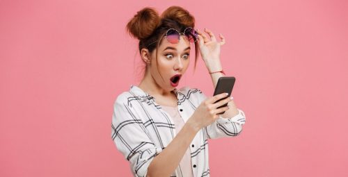A shocked woman looking at a smartphone