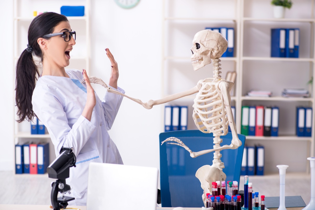 Woman Playing With a Skeleton in the Lab Funny Stock Photos