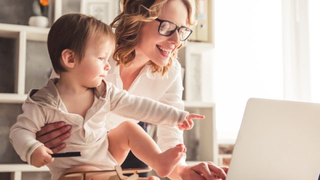 mom holding baby while working on laptop, prepare children for divorce