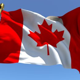 Canadian Flag blows in wind, Canadian traditions Americans should adopt