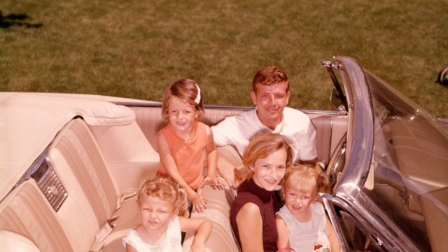 1960s white family with father, mother, daughter on lap in front seat, and two daughters in back seat, things that would horrify parents today