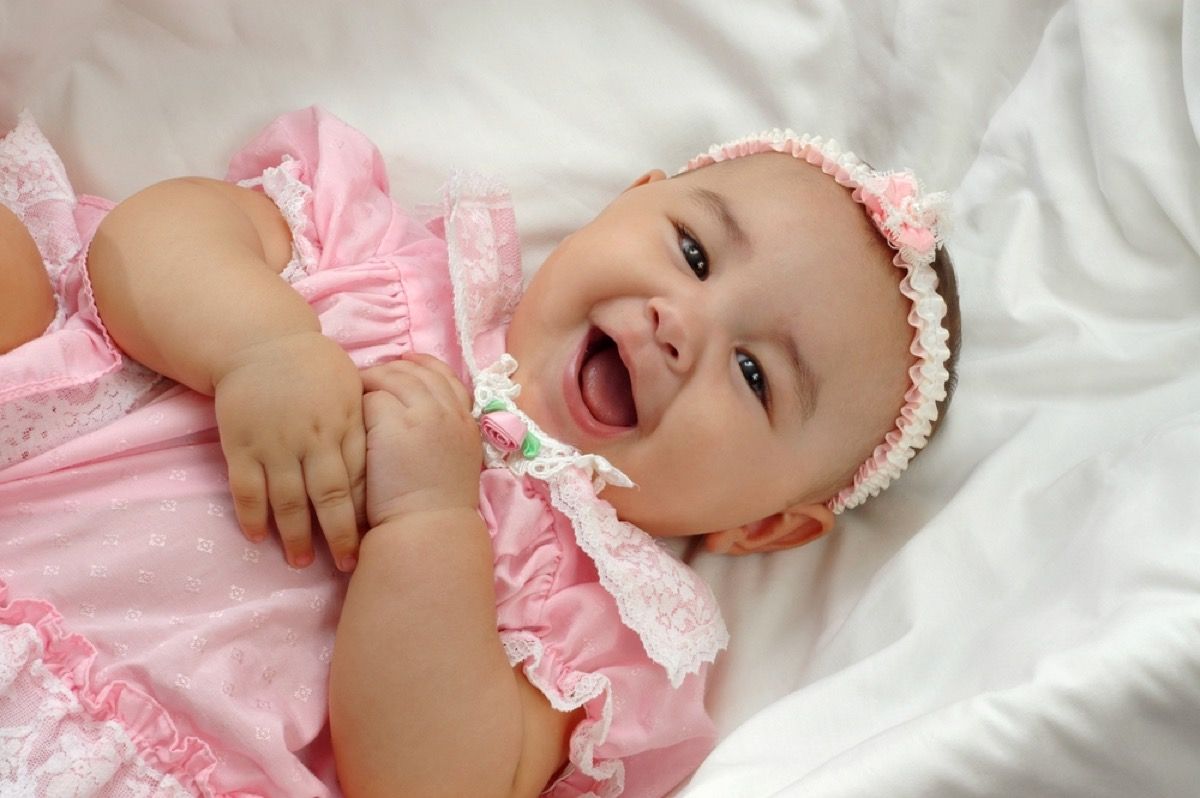 baby meisje lachen in roze jurk, manieren Ouderschap is veranderd.