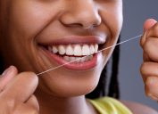 Black Woman Smiling and Flossing, subtle symptoms of serious disease