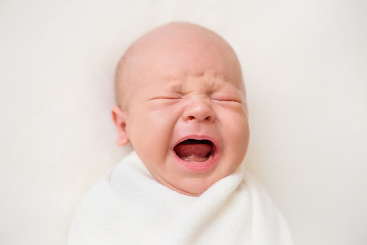 crying newborn baby in swaddle, parenting tips