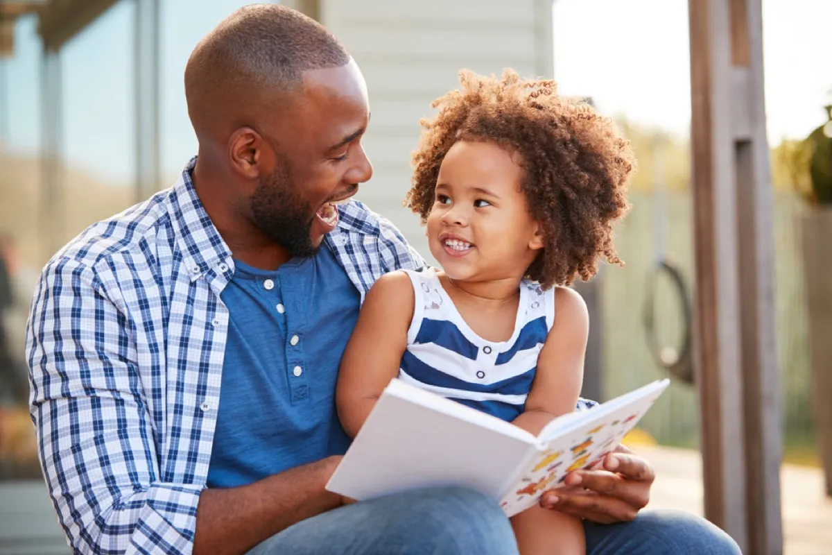 dad reading a book to his young daughter, prepare children for divorce