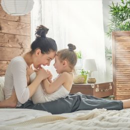 happy mother with child in bed, parenting myths