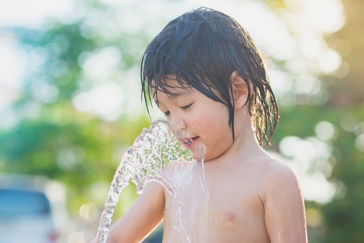 young boy drinking from garden hose, bad parenting advice