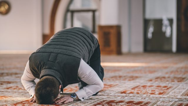 Muslim Man Kneeling on the Ground and Praying for Ramadan