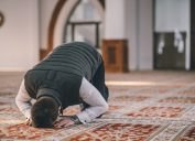 Muslim Man Kneeling on the Ground and Praying for Ramadan