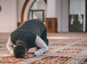 Muslim Man Kneeling on the Ground and Praying for Ramadan