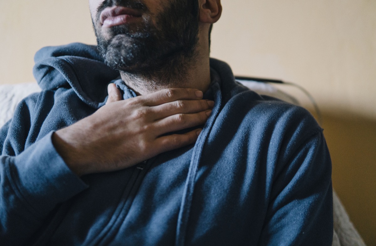 Young adult man suffering from sore throat