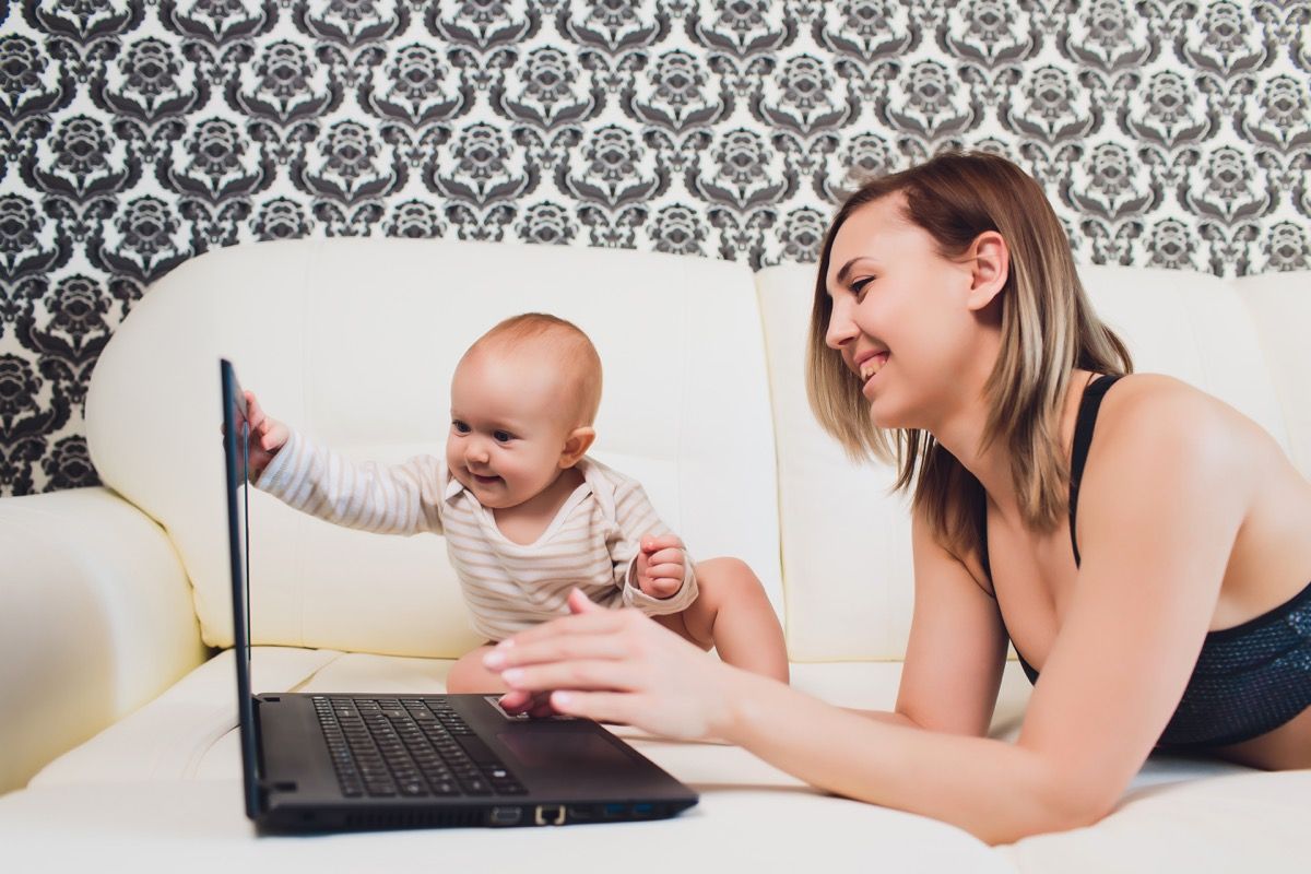 mor på computeren sidder ved siden af hendes Baby, måder forældre har ændret sig.