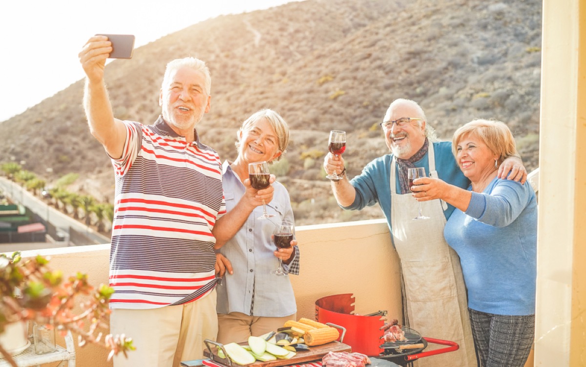 older couples taking photo while drinking wine, empty nest