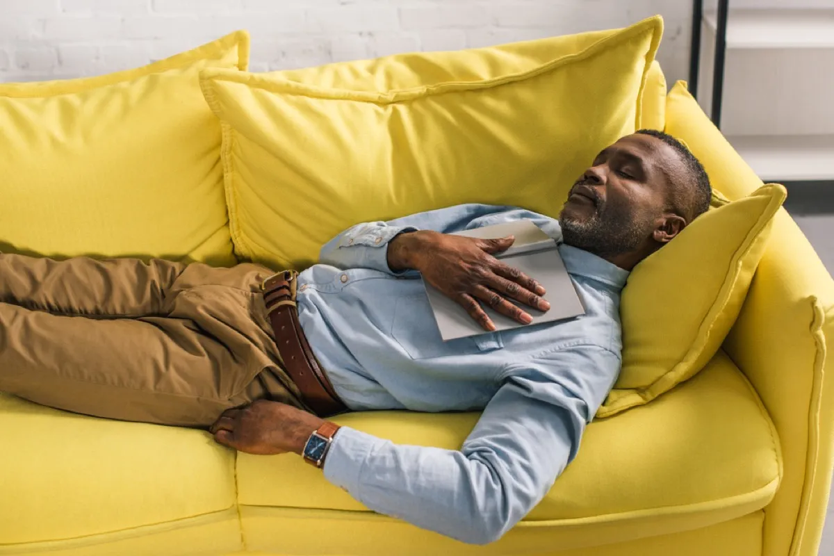 middle-aged man napping on yellow couch, health questions after 40