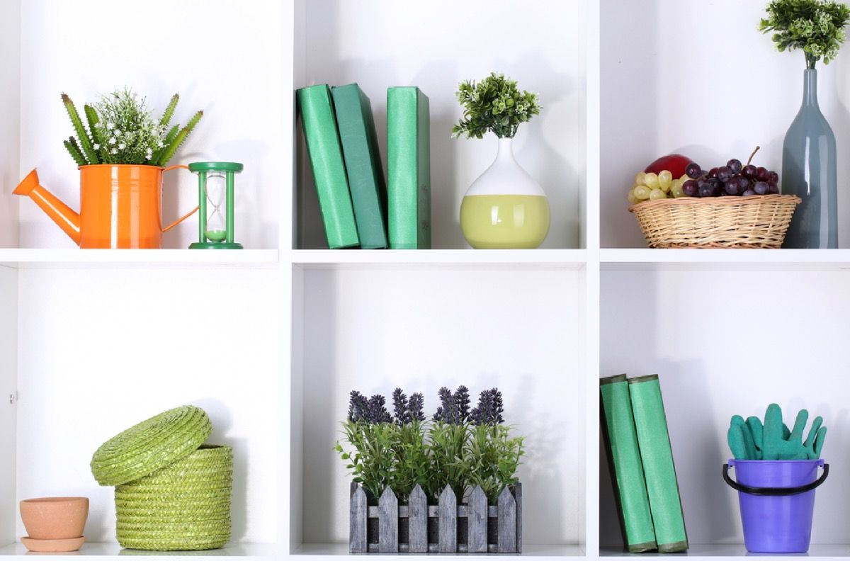 open shelves with green books and plants, joanna gaines tips