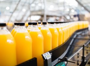 Bottling factory - Orange juice bottling line for processing and bottling juice into bottles. Selective focus.