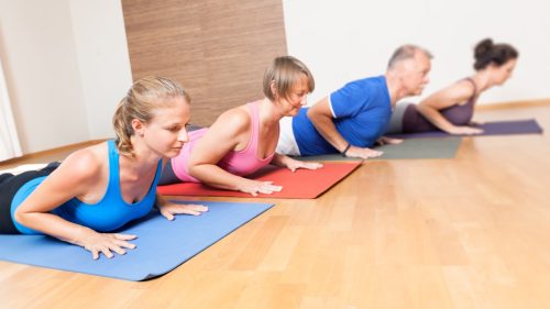group of older people doing pilates and yoga for exercising, over 50 fitness