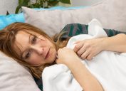 Woman sick in bed with night sweats