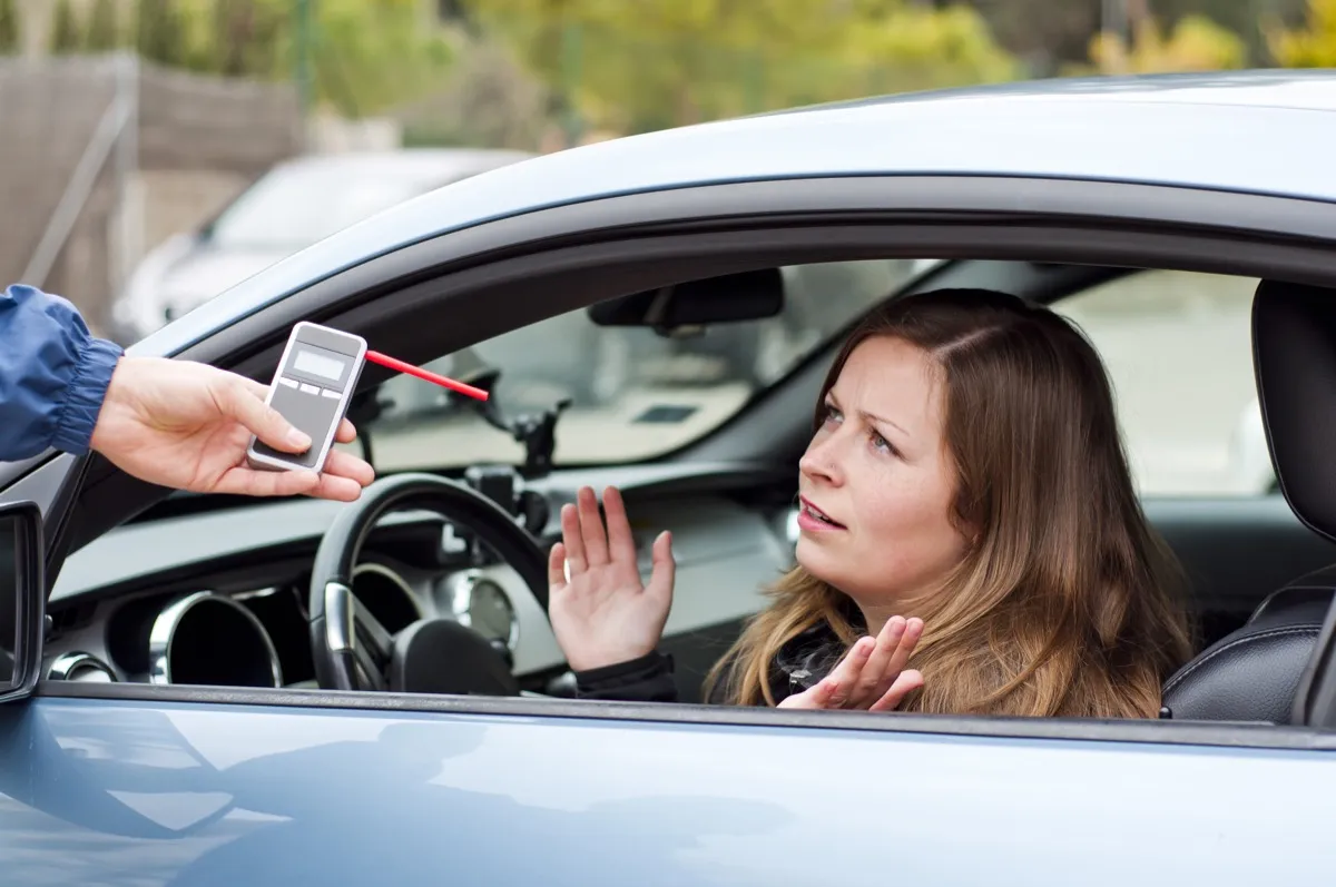 woman taking breathalyzer things you should never do when getting pulled over