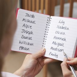 woman writing down a list of baby names, things that annoy grandparents