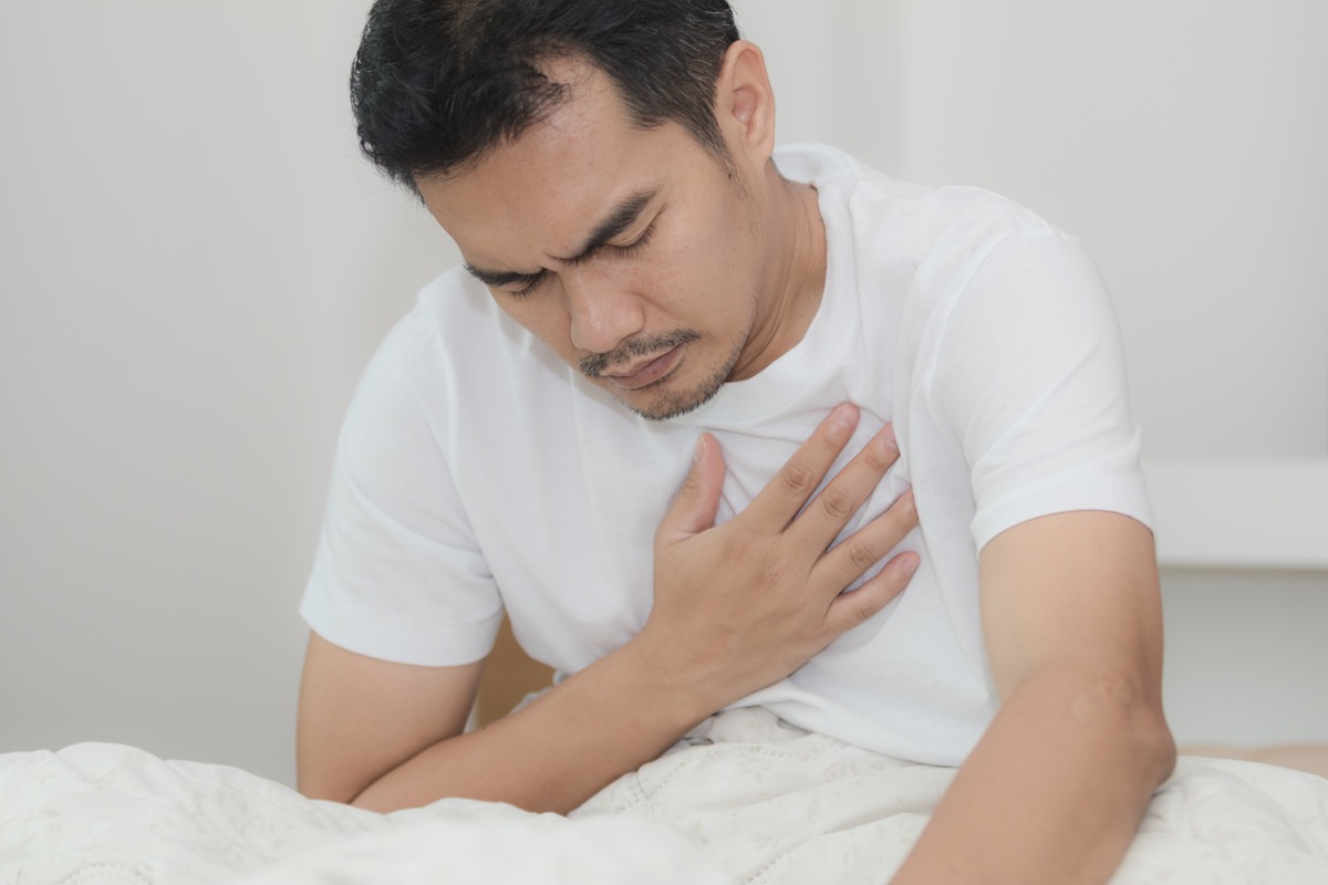 Asian Man Holding His Chest in Pain from Pneumonia Misdiagnosed Men's Health issues