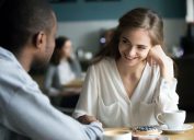 người phụ nữ trẻ mỉm cười với người đàn ông trong quán cà phê