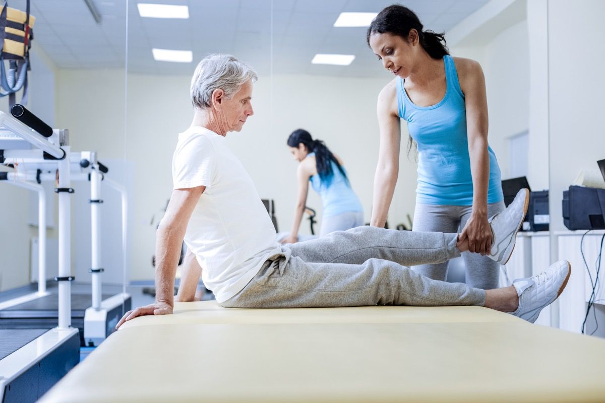 man's body feels weak so a woman is checking his leg