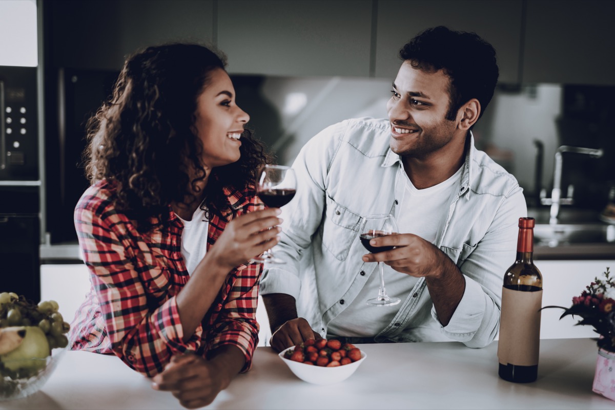couple drinking red wine in the kitchen during the day time