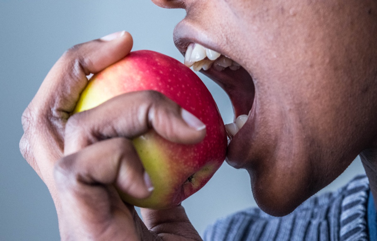 Person Eating a Red and Green Apple Tongue Health
