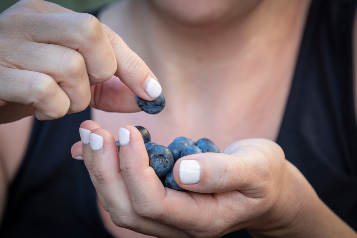 Eine Frau, die Beeren isst, senkt den Blutdruck auf natürliche Weise
