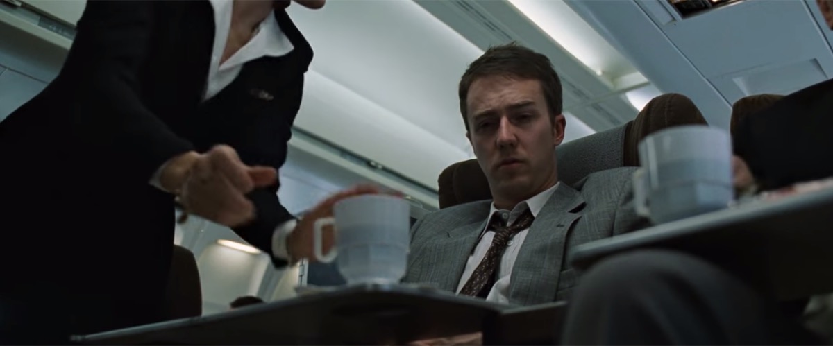 fight club character starring at a coffee cup on a plane