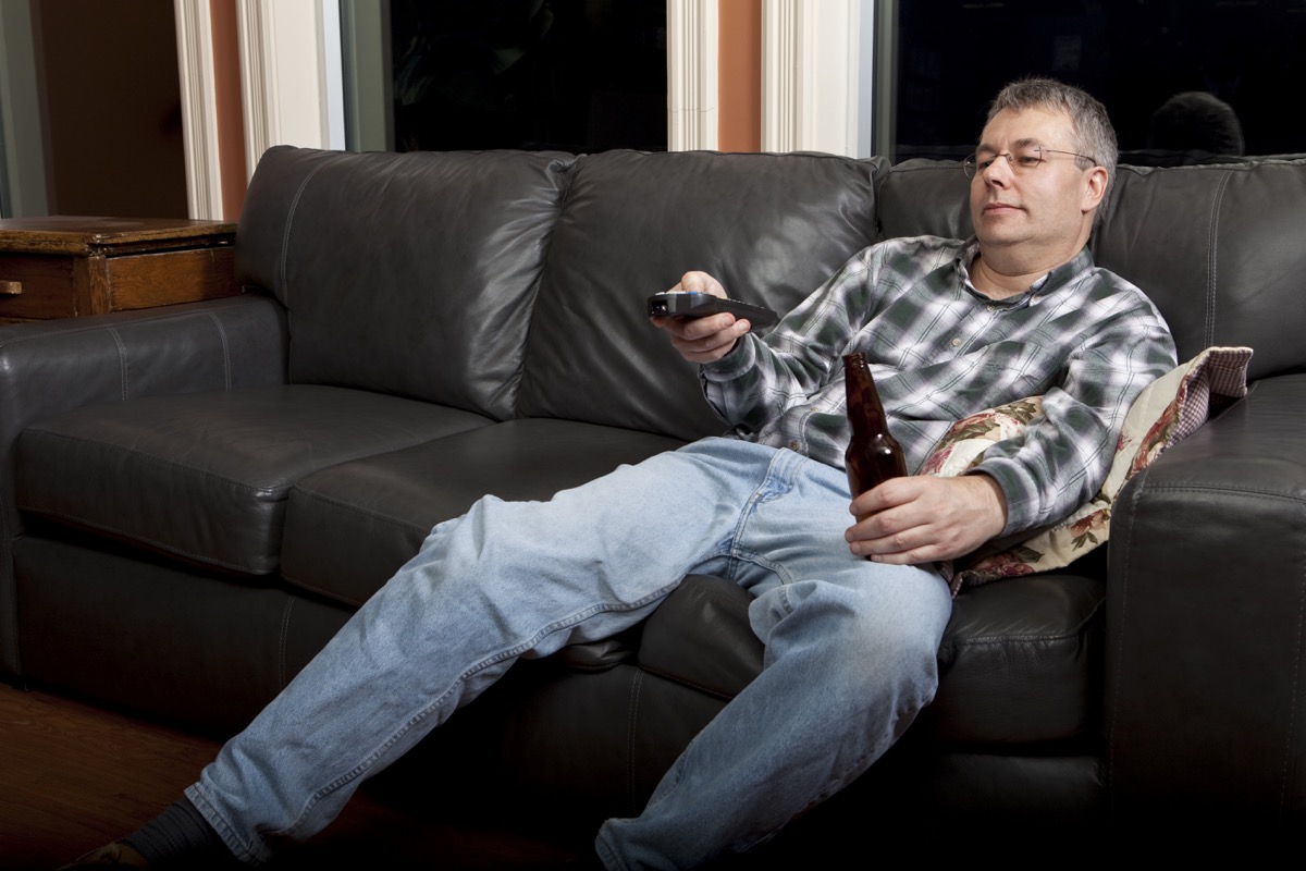 man watching tv drinking a beer