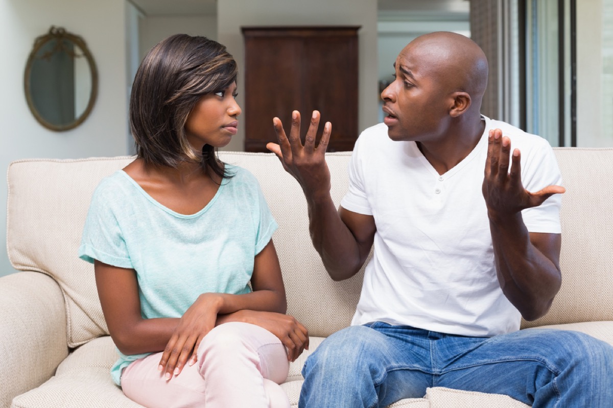 man fighting with girlfriend on couch, things you should never say to your spouse