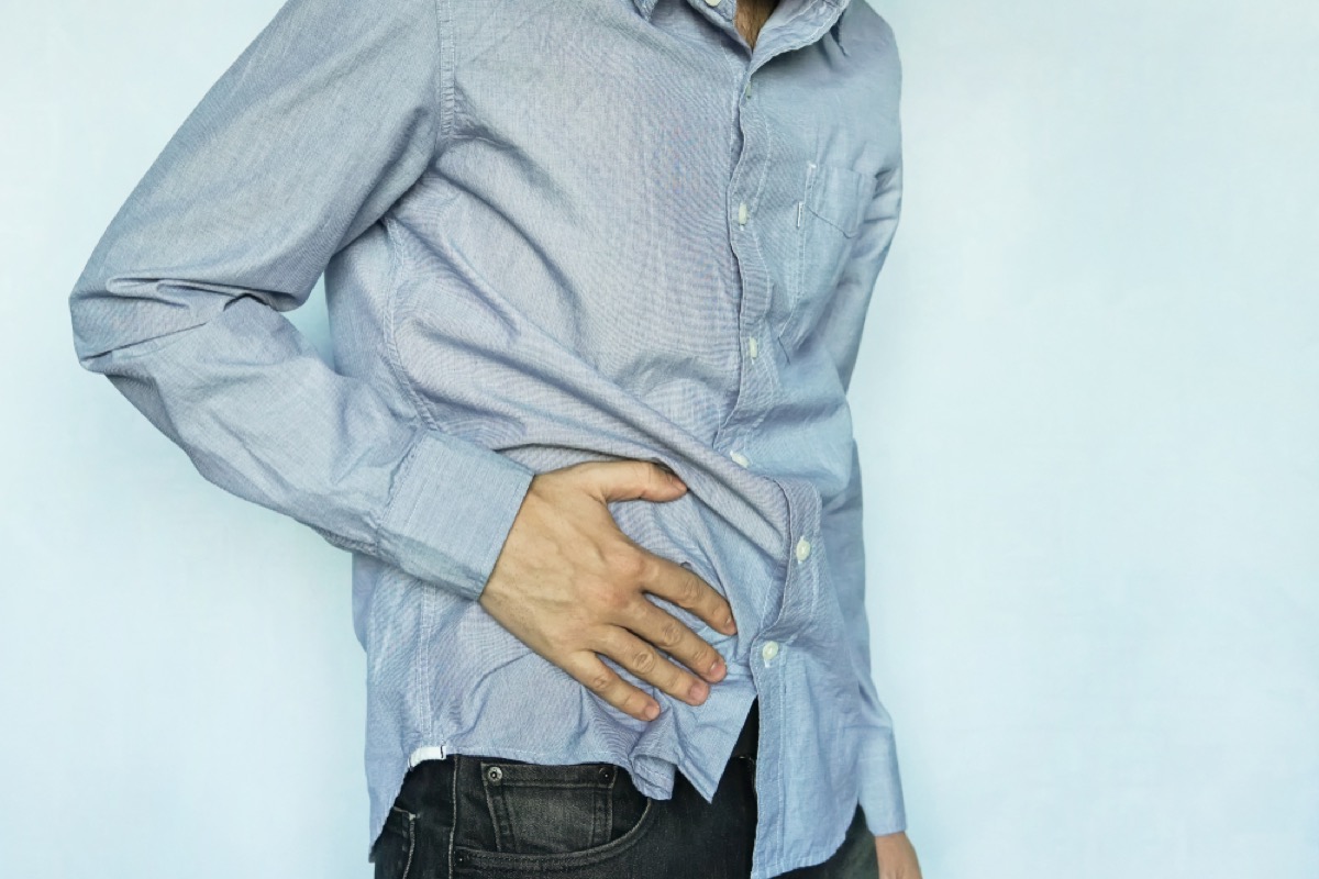 man holding abdomen in pain, stomach symptoms