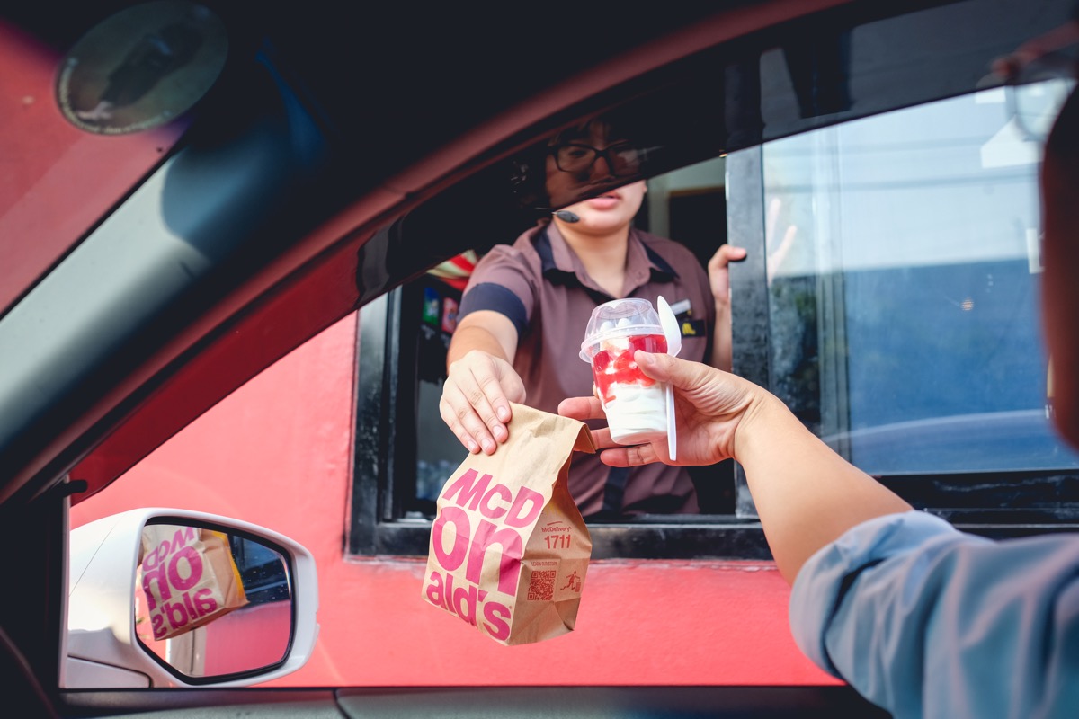 mcdonalds employee handing food at drive-thru, new words coined