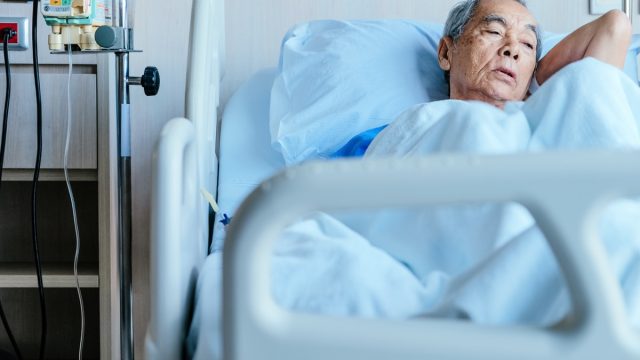 Older Asian Man Lying in a Hospital Bed, over 50 regrets