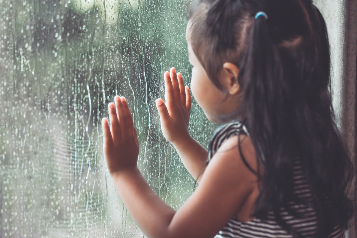 little girl looking at rain on the window, every day words