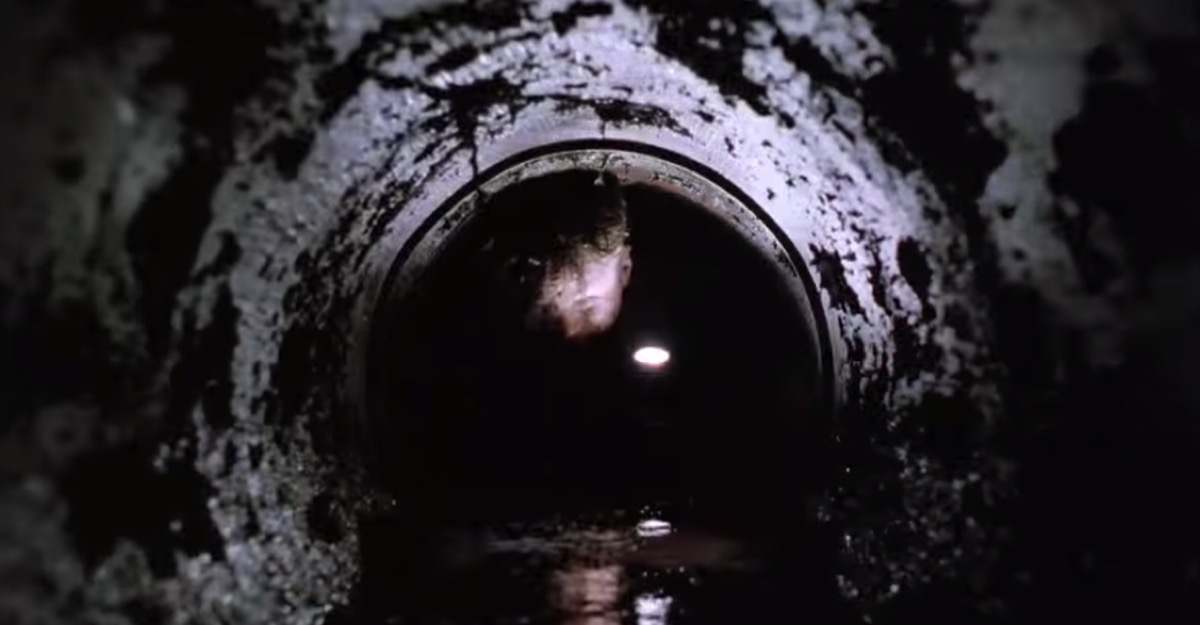man crawling through a pipe