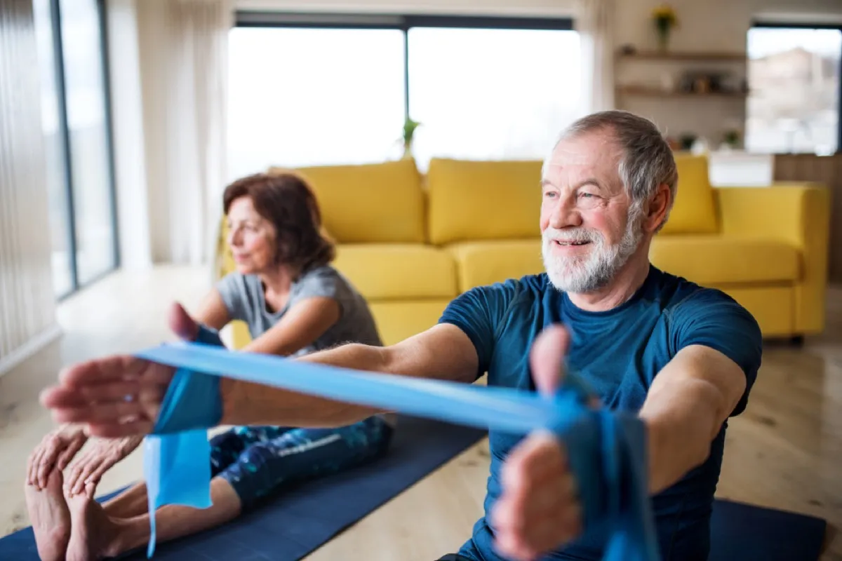 older white man and woman exercising at home