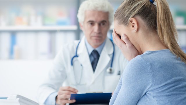 female patient receives bad news with older male doctor