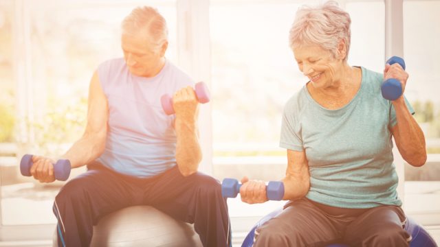 elderly couple happily exercising