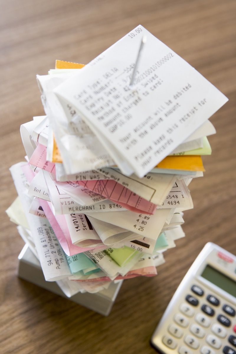 stack of receipts on desk in home toss these things from your house for instant happiness