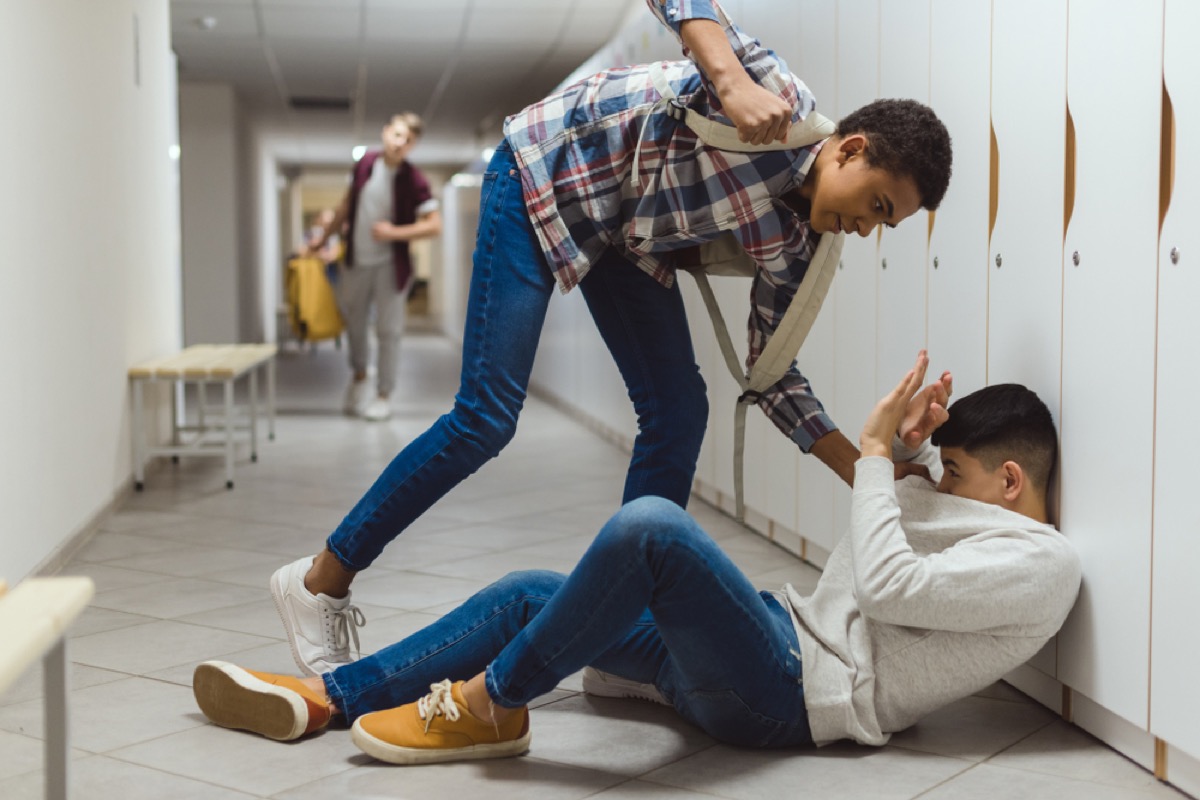 teenage kid punching young man in hallway, bad parenting