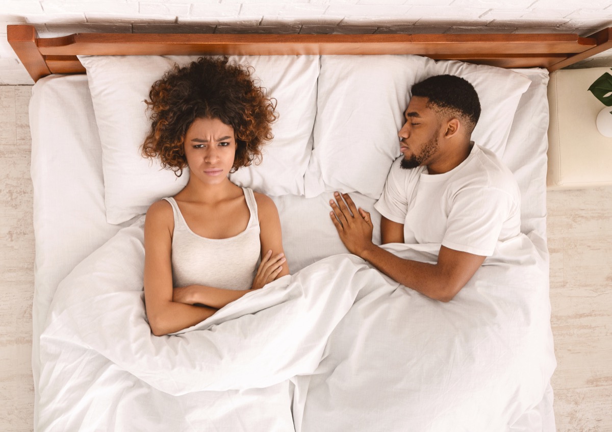 upset young black woman in bed