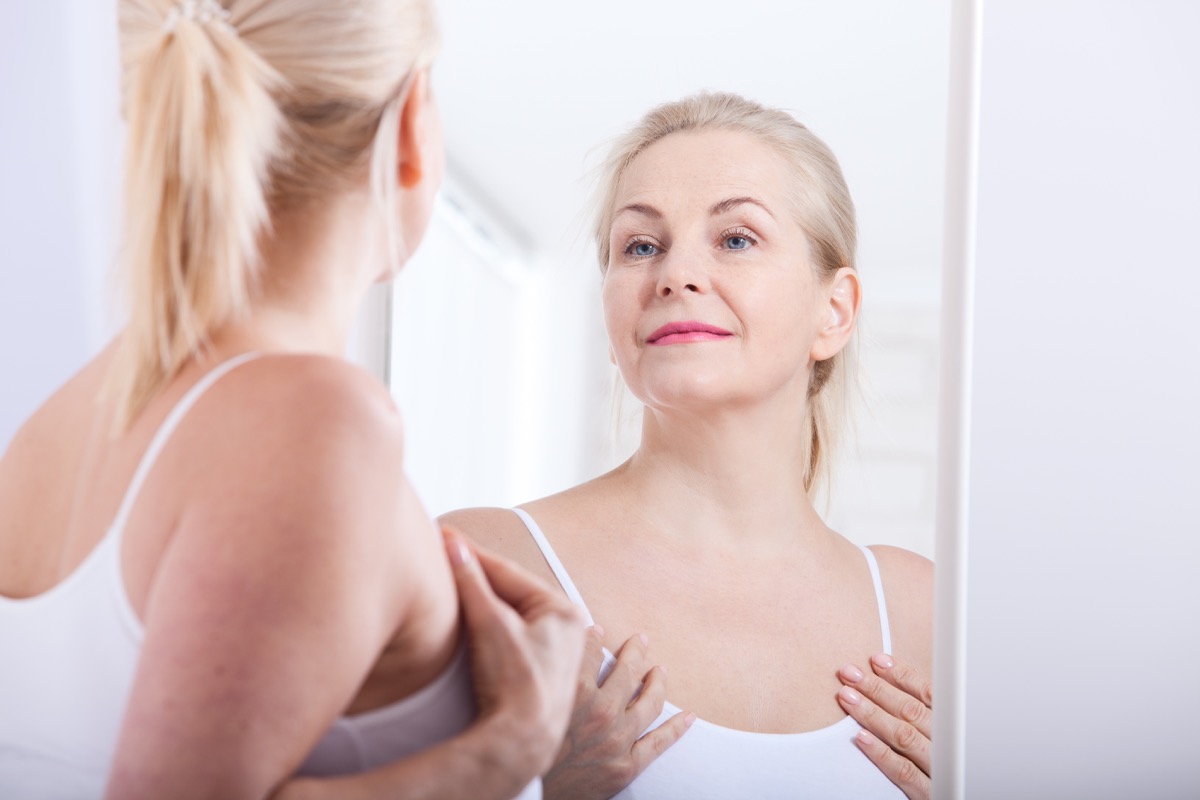 woman looking in mirror, ways to feel amazing