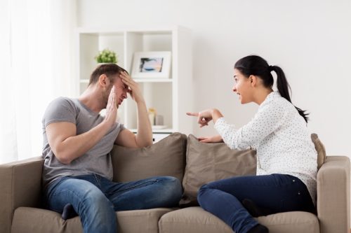 young white woman yelling at man on couch