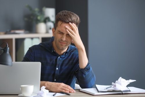 Man stressed and agitated while working at his desk
